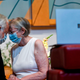 Linda Hoveskeland (R) and Ardell Hoveskeland share a moment with family and friends joining over Zoom after their socially distanced wedding at the Peace Lutheran Church in Alexandria, Virginia on May 28, 2020.